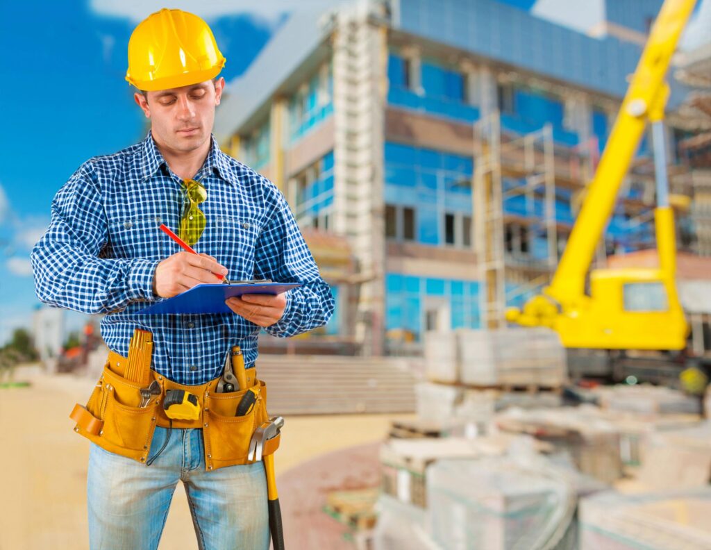 "a man wearing a hard hat and holding a clipboard"