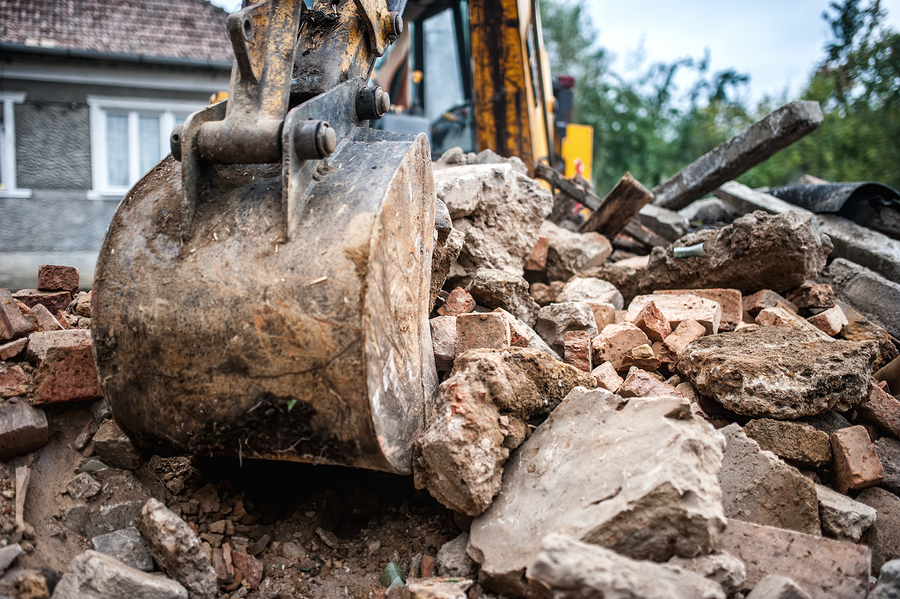 "a bulldozer digging through a pile of rubble"